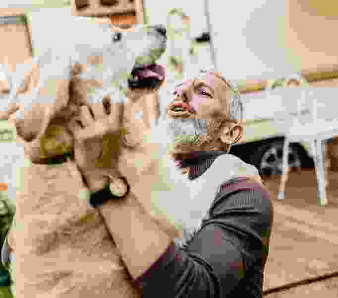 man hugging his dog with big smile